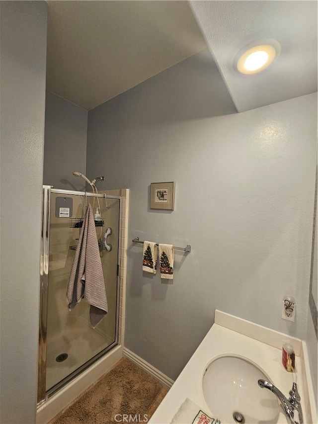 bathroom featuring vanity and a shower with door