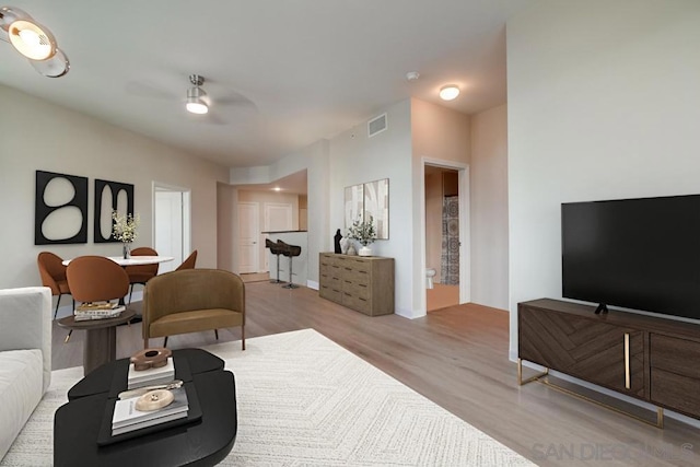 living room featuring ceiling fan and light hardwood / wood-style floors