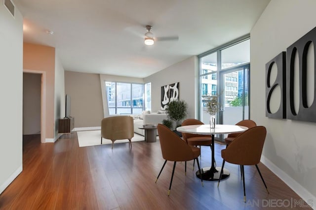 dining space featuring ceiling fan, expansive windows, and hardwood / wood-style floors