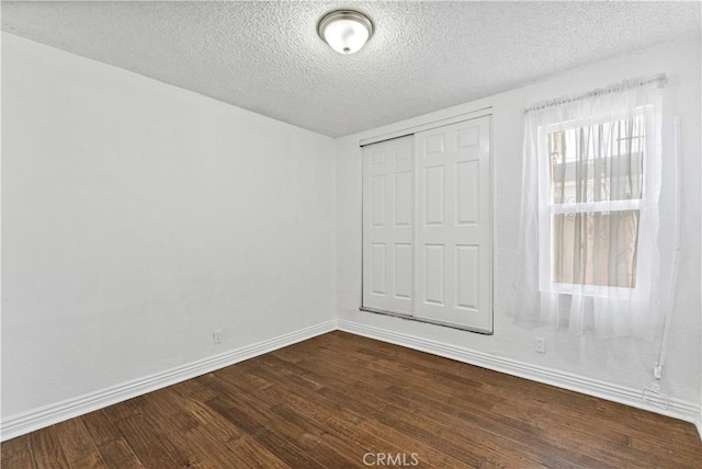 unfurnished bedroom featuring a closet, a textured ceiling, and wood-type flooring