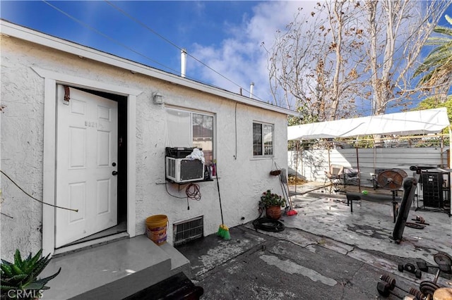 view of exterior entry with a patio area and cooling unit