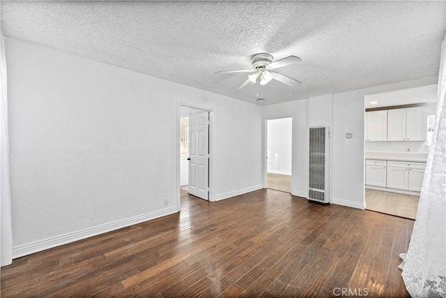 unfurnished room featuring ceiling fan, dark hardwood / wood-style flooring, and a textured ceiling