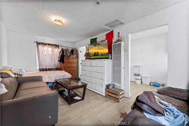 living room with light wood-type flooring and a textured ceiling