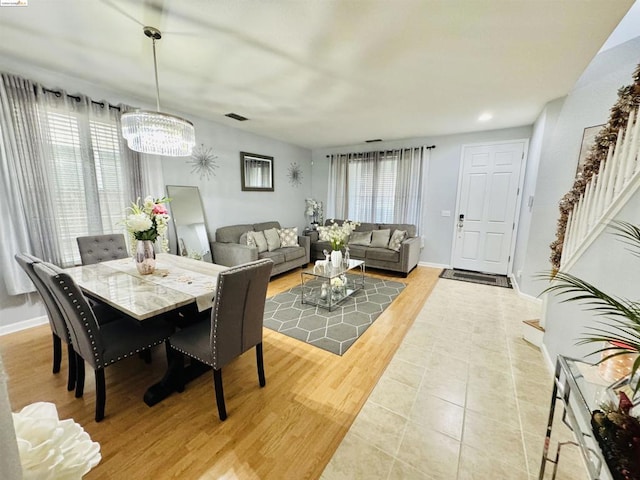 dining room featuring a healthy amount of sunlight, a chandelier, and light hardwood / wood-style floors