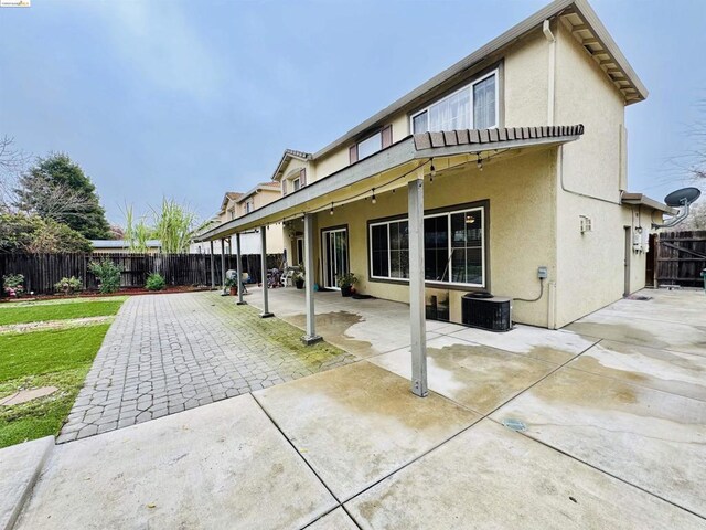 rear view of house with central AC and a patio