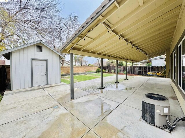 view of patio featuring cooling unit and a storage shed