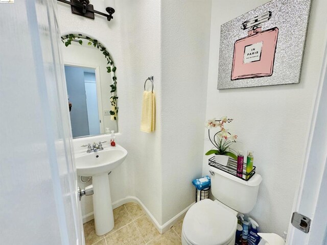 bathroom with sink, toilet, and tile patterned flooring