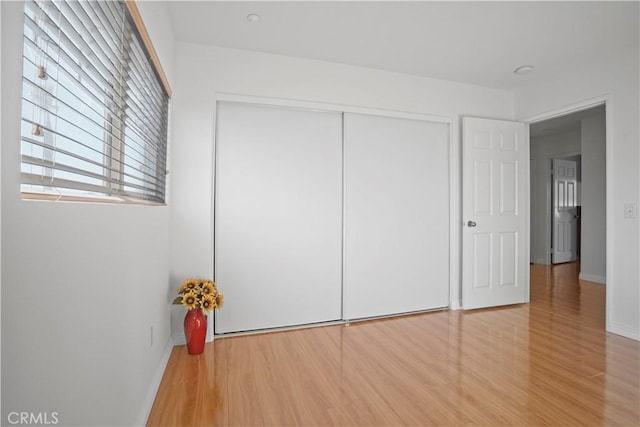 unfurnished bedroom with a closet and hardwood / wood-style flooring