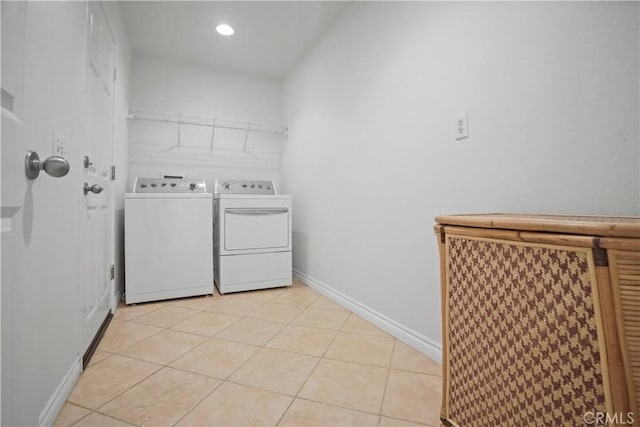 laundry area with light tile patterned floors and washing machine and clothes dryer