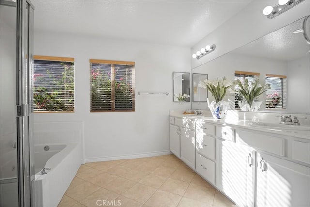 bathroom featuring vanity, plenty of natural light, a bathing tub, and tile patterned floors