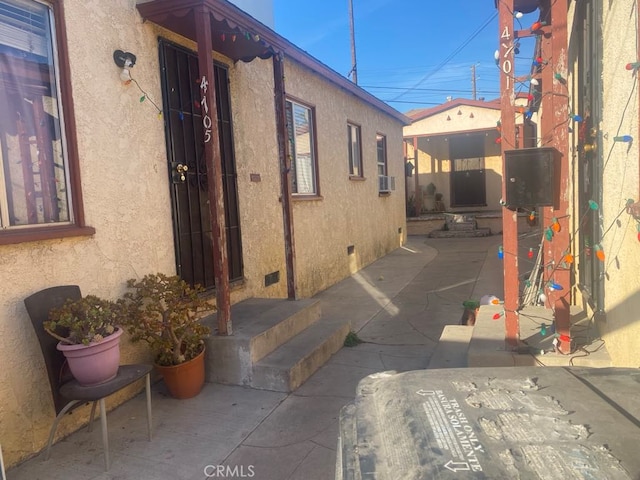 view of side of property with cooling unit and a patio