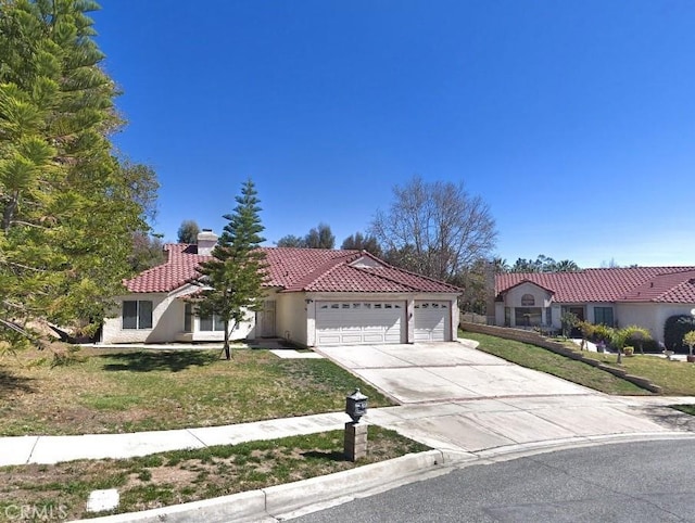 mediterranean / spanish-style house featuring a front lawn and a garage