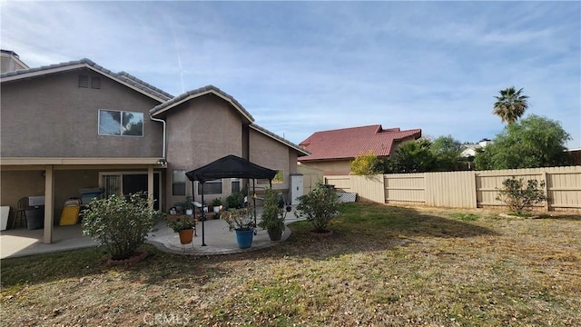 back of house with a patio area and a lawn