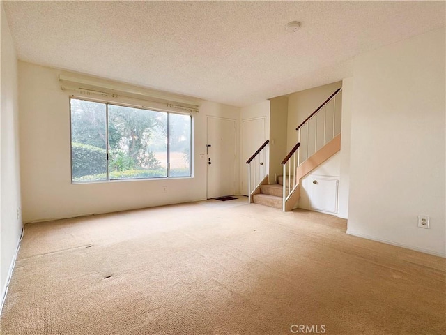 unfurnished living room with a textured ceiling and light carpet