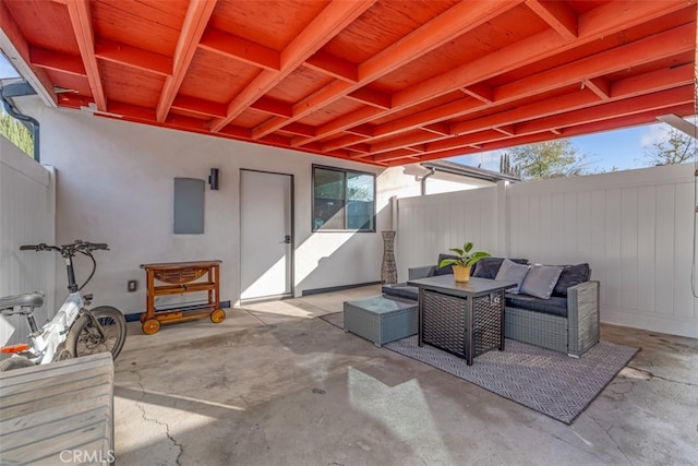 view of patio / terrace featuring an outdoor living space, fence, and electric panel