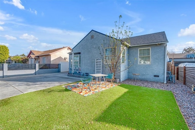 back of house with stucco siding, a lawn, crawl space, a patio area, and fence