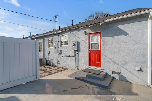 exterior space featuring a patio, fence, and stucco siding