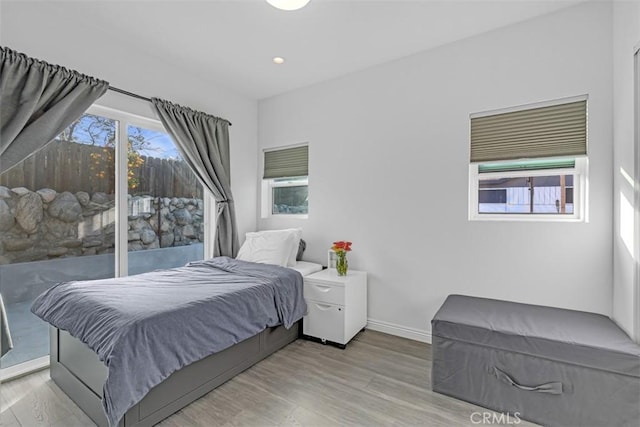 bedroom featuring baseboards, recessed lighting, wood finished floors, and access to exterior