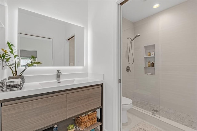 bathroom featuring tiled shower, vanity, toilet, and recessed lighting