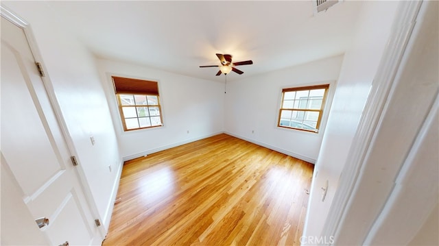 unfurnished bedroom with light wood-style floors, visible vents, multiple windows, and baseboards