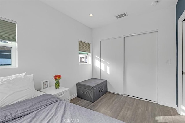 unfurnished bedroom featuring a closet, visible vents, and wood finished floors