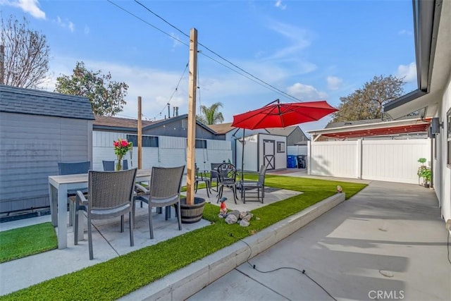 exterior space with outdoor dining area, a fenced backyard, an outdoor structure, and a storage shed