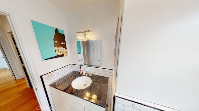 bathroom with backsplash, vanity, and wood finished floors