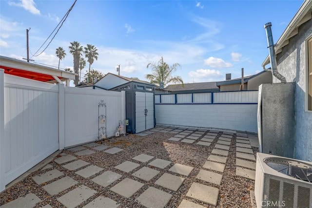 view of patio / terrace with a storage shed, an outdoor structure, and a fenced backyard