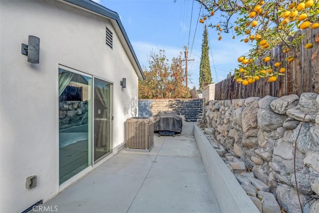 view of patio featuring fence, grilling area, and cooling unit