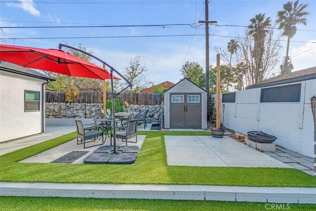 view of patio / terrace with a shed, a fenced backyard, and an outbuilding