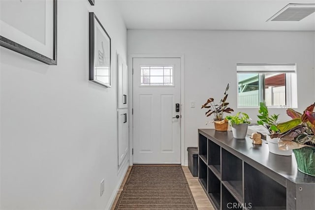 entryway with light wood-style floors, visible vents, and a healthy amount of sunlight