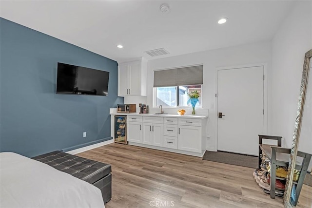 bedroom featuring wine cooler, recessed lighting, a sink, visible vents, and light wood finished floors