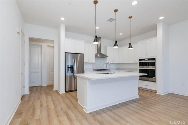 1053 Cadence, Irvine, CA 92618 - kitchen featuring wall chimney exhaust hood, sink, hanging light fixtures, stainless steel appliances, and a kitchen island with sink