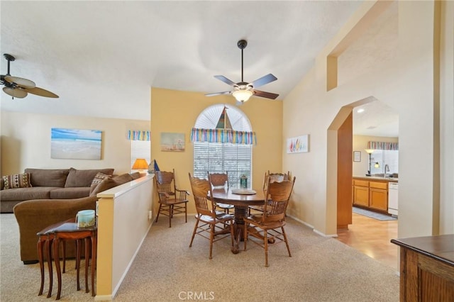 carpeted dining room with sink, ceiling fan, and lofted ceiling