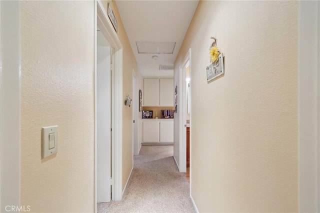 hallway featuring light colored carpet