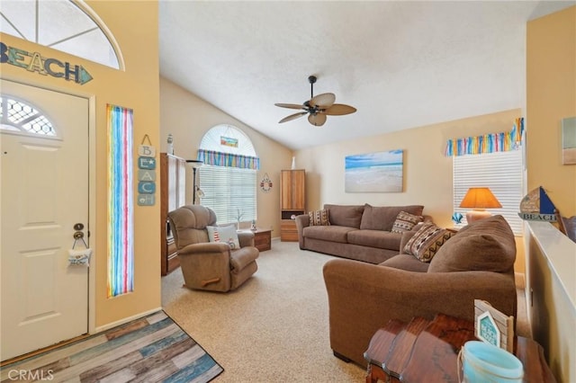 carpeted living room featuring ceiling fan and high vaulted ceiling