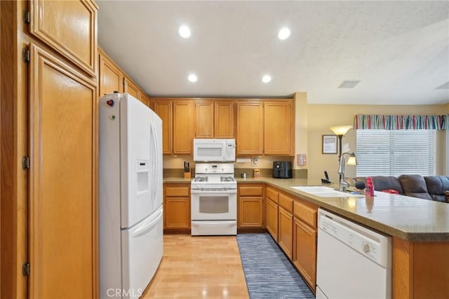 kitchen featuring kitchen peninsula, white appliances, sink, and light hardwood / wood-style floors