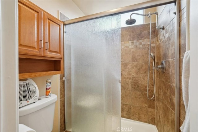 bathroom with a shower with door and toilet