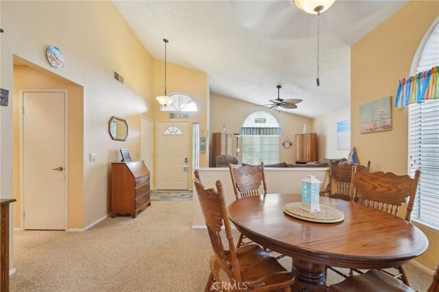 carpeted dining area featuring ceiling fan and high vaulted ceiling