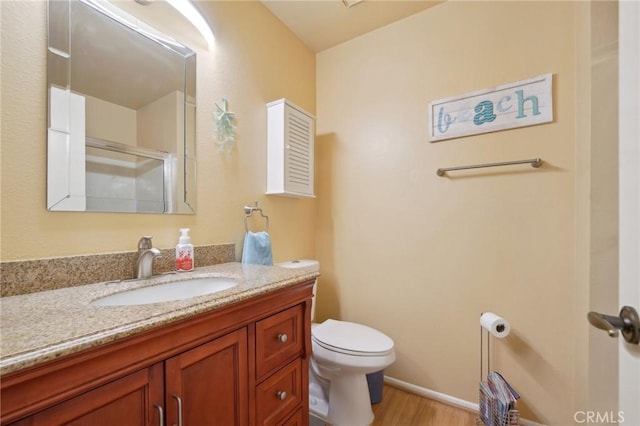 bathroom with vanity, hardwood / wood-style flooring, an enclosed shower, and toilet