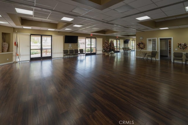 interior space with french doors, a drop ceiling, and dark hardwood / wood-style flooring