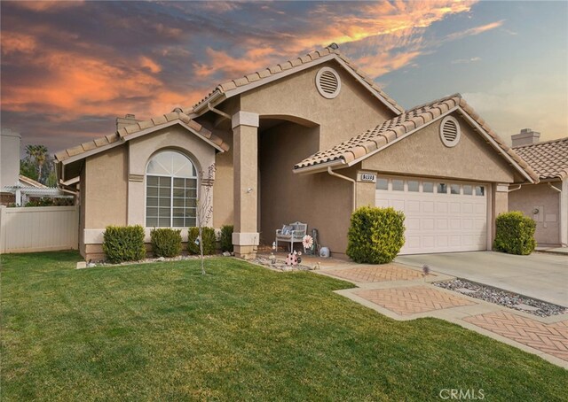 view of front of house featuring a garage and a lawn