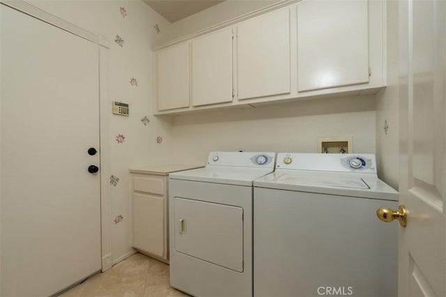 laundry room with washer and dryer, cabinets, and light tile patterned flooring