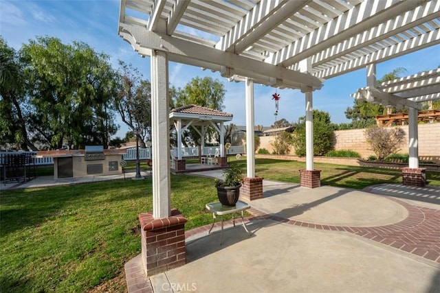 view of patio / terrace with a pergola, area for grilling, and exterior kitchen