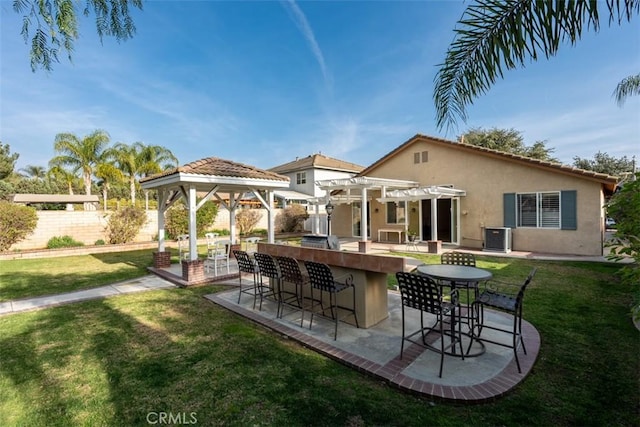 rear view of house with exterior bar, a yard, cooling unit, and a pergola