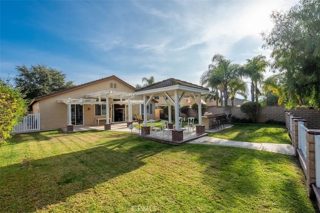 back of property with a pergola, a lawn, an outdoor kitchen, exterior bar, and a patio