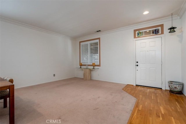 foyer entrance featuring crown molding and carpet flooring