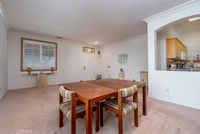 dining room with light colored carpet and ornamental molding