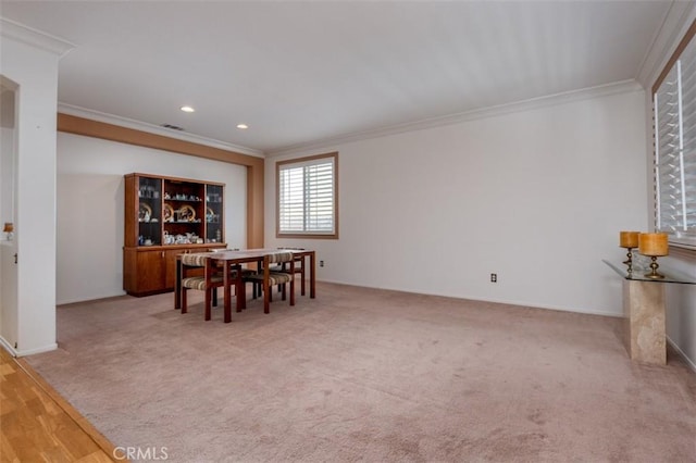 dining area with ornamental molding and carpet flooring