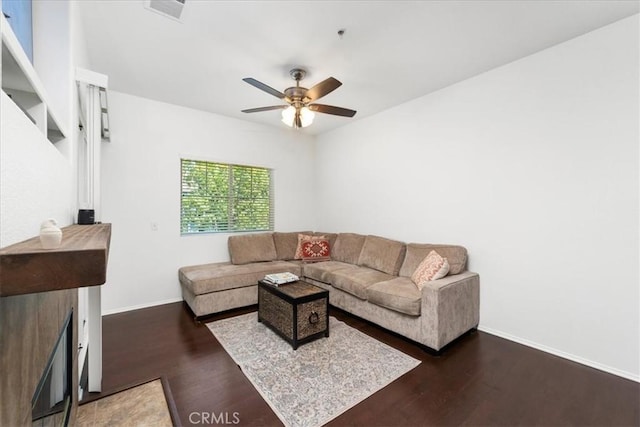 living room featuring dark wood-type flooring and ceiling fan